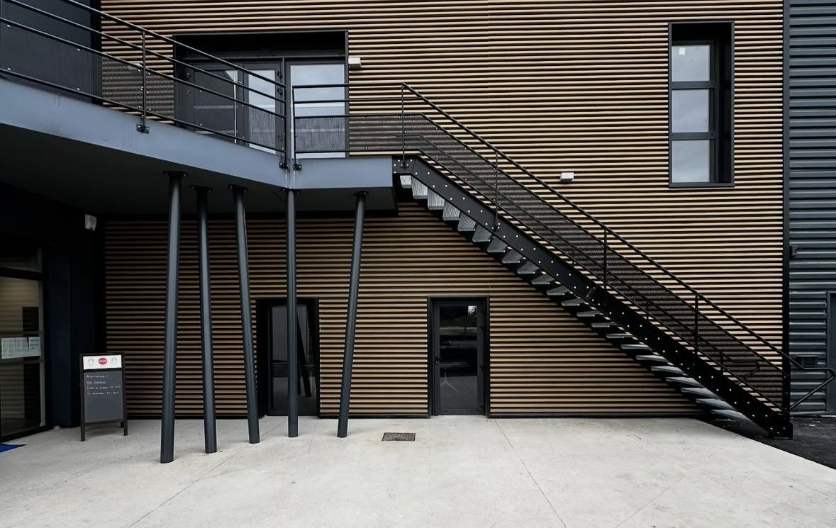Escalier extérieur en acier sur façade à bardage