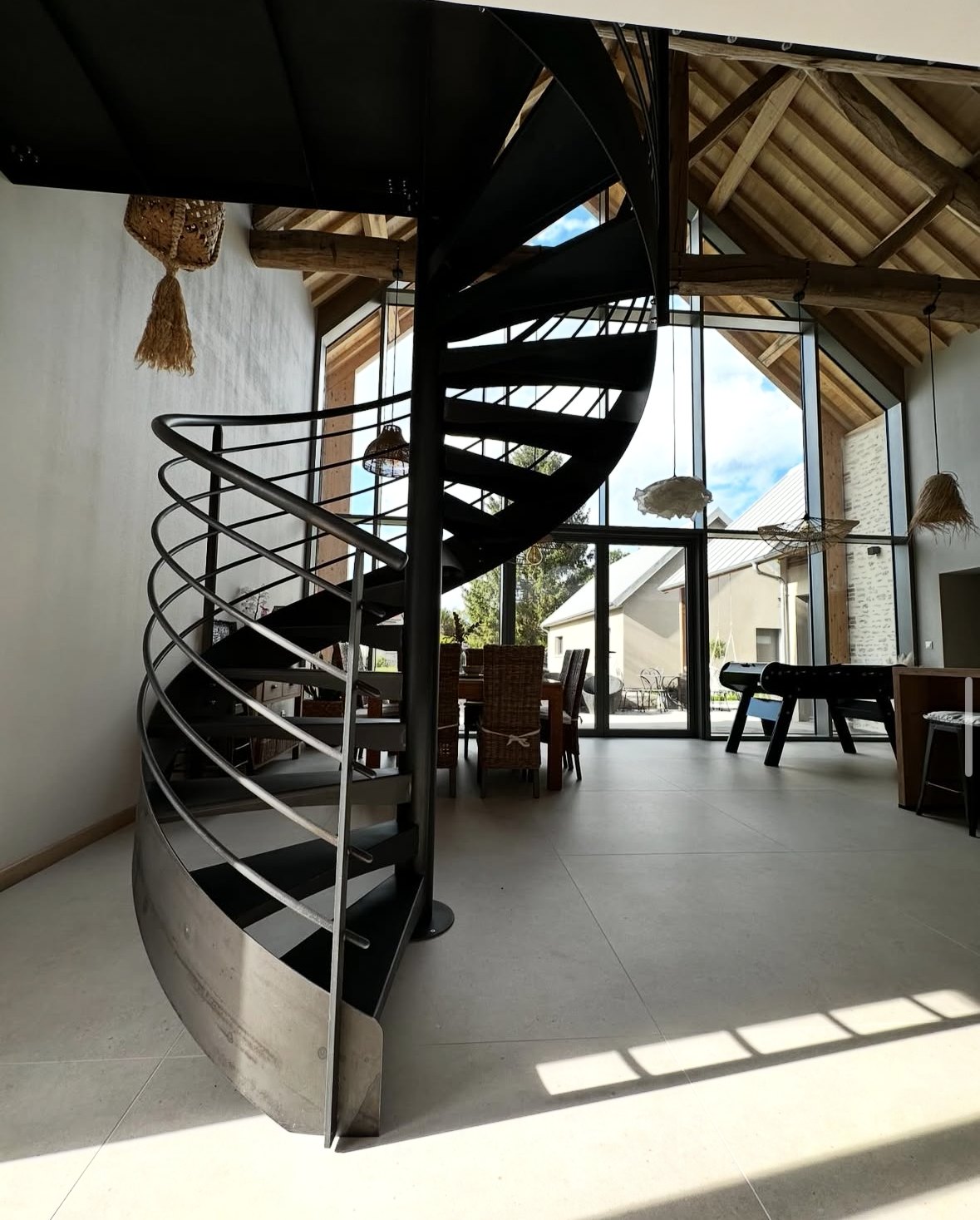 Escalier hélicoïdal en acier brut dans une longère rénovée